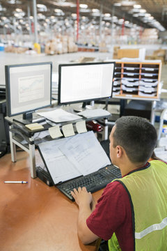 Man working on computer in warehouse