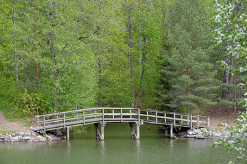 Fototapeta na wymiar Pedestrian wooden bridge over stream