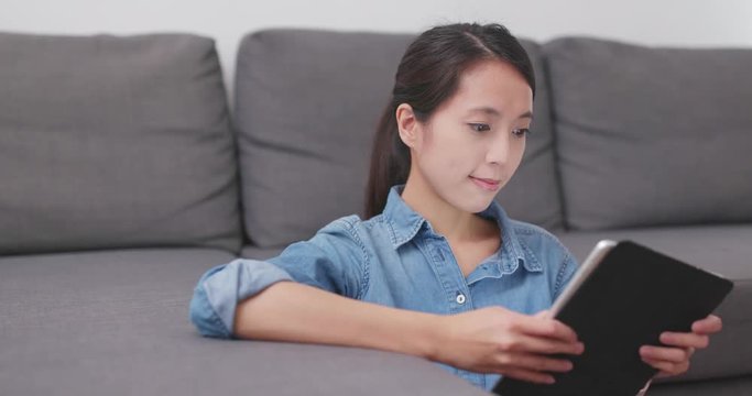 Woman watching on tablet computer at home