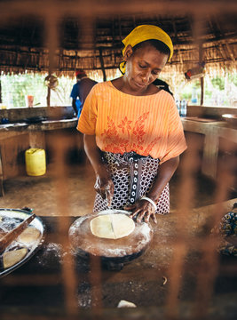 Rural African villager making bread and cooking in her kitchen