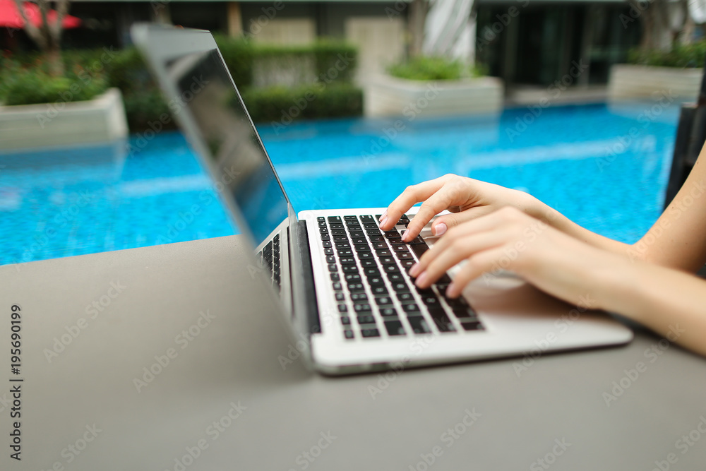 Wall mural woman fingers typing on computer keyboard. close up portrait of hands pressing buttons on laptop at 