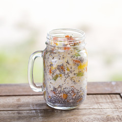 Healthy food, chia seed pudding with mango, green grapes, papaya, oat flakes, coconut milk and muesli, vitamin breakfast in glass mug. Morning in Thailand