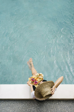 Girl posing on poolside with fruit plate