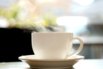 Hot coffee with smoke on the table   sunlight in morning  , bokeh  background