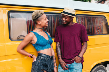Mixed race couple with a yellow camper van
