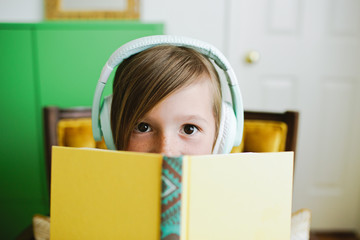 Young girl reading along while listening to a book