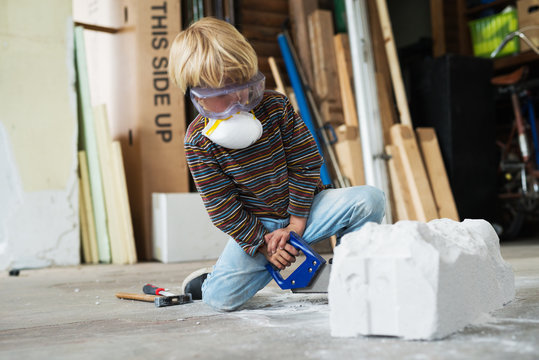 Boy in workshop using differnt tools for sculpting