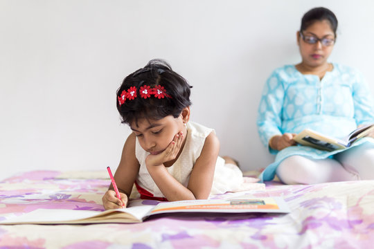 Mother and daughter busy in their respective studies