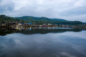 Fototapeta na wymiar Water Village at the edge of river in front of the mountain in countryside of Thailand