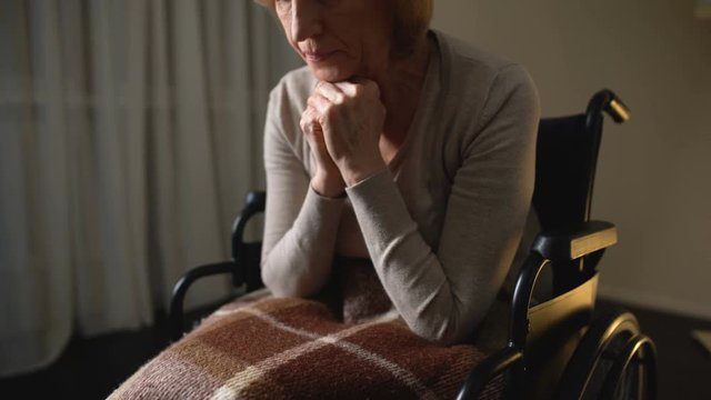Sick woman wheelchair feeling lonely and depressed, hopelessness in nursing home