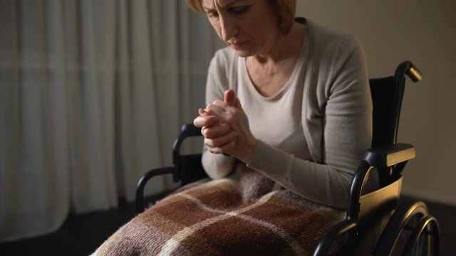 Senior lady looking at shaking hands and crying, symptoms of alzheimers disease