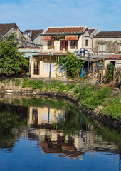 Fototapeta na wymiar reflections of a neighborhood in old Hoi An on a canal