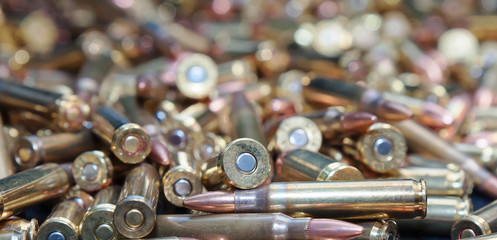 A close up of a pile of .223 and 45 caliber as well as 9mm bullets