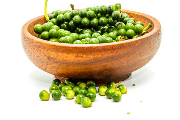 Close up of fresh green peppercorns on a wooden cup