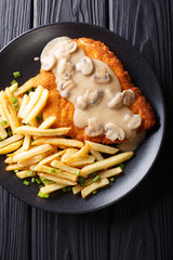 Crispy Fried Pork Chops (Jaeger Schnitzel) with sauce and french fries close-up. Vertical top view