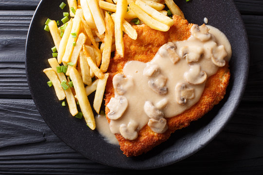 Crispy Fried Pork Chops (Jaeger Schnitzel) with sauce and french fries close-up. horizontal top view