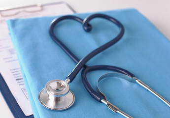 A stethoscope shaping a heart on a medical uniform, closeup