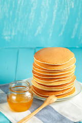 Vertical photo of stack of pancake with honey and butter