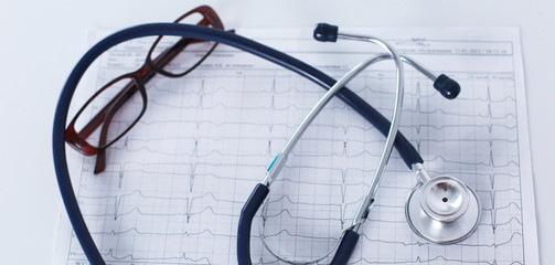 Fototapeta premium Stethoscope on cardiogram concept for heart care on the desk.blue toned images