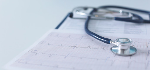 Stethoscope on cardiogram concept for heart care on the desk.blue toned images