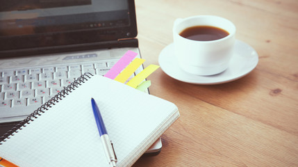 office working desk top view with laptop, notepad and coffee