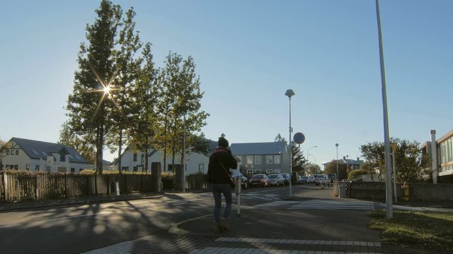 car traffic in a small suburb in a morning, cold sunny weather, cars are moving