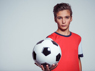 Photo of teen boy in sportswear holding soccer ball