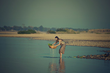 Asian woman washing vegetable and working in Mekong river,Nongkhai Thailand.