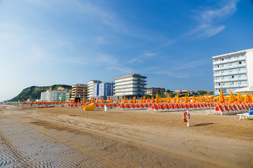 Empty beach with a lot of sunbeds and umbrellas in the morning. Pesaro, Emilia Romagna, Italy.