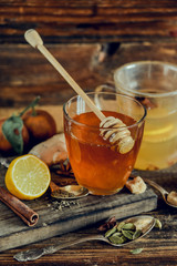 Vitamin medicinal tea with lemon and honey, ginger and spices on wooden background . The concept of spring beriberi and colds.