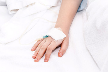Little girl hand with IV saline intravenous in hospital