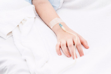 Little girl hand with IV saline intravenous in hospital