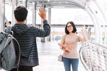 Woman student waving hello with her friend - friendship and togetherness concept © Art_Photo