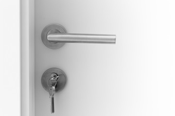 Closeup white Door handle metal with key to unlock or locking door