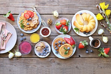 Easter dessert table. Pancakes,waffles and bundt cake with fresh berries and various of topping. Overhead view, copy space