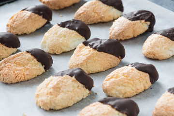 Homemade coconut and chocolate cookies on baking paper, selective focus