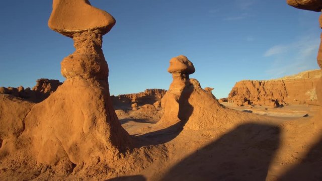 Moving through hoodoos in Goblin Valley during sunset in Utah  as the landscape glows.