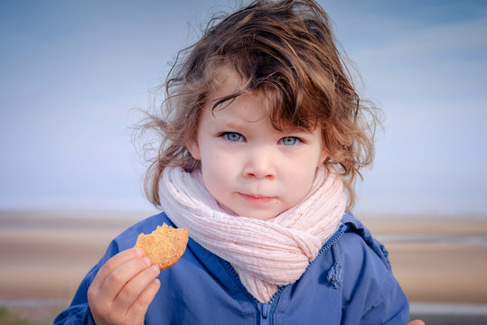 belle enfant mangeant un biscuit