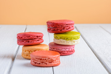 Different types color of macaroons on white wooden background