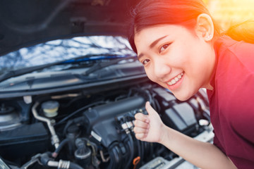 Fototapeta na wymiar Asian women thumbs up good car engine check up before go trip