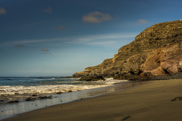 Fototapeta na wymiar Beach on Fuerteventura with a lava rock in the background