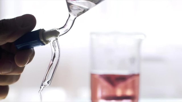 Scientist working with chemical reaction in an Erlenmeyer flask in chemical laboratory