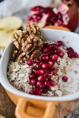 Breakfast: granola with pomegranate and walnuts and green Apple on natural wooden background rustic. The concept of healthy and high-carbon nutrition.