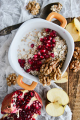 Tasty homemade Breakfast: oatmeal with pomegranate and nuts on natural wooden background rustic. The concept of a healthy diet, a high-carbon Breakfast.
