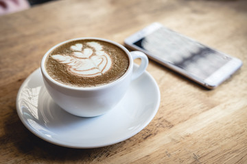 Cup of green tea latte art on wooden table