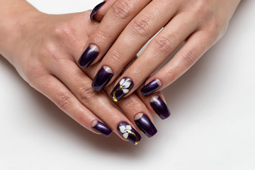 dark purple manicure on square long nails with white flowers on ring fingers
