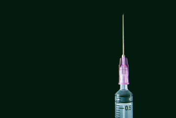 Medical syringe on the dark.