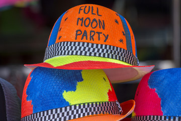 Naklejka premium Decorated colorful hats sold on the beach before of the Full moon party on the island of Koh Phangan, Thailand
