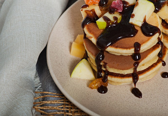 Sweet pancakes with fruits, candied fruits and cheese, homemade, on a light background.