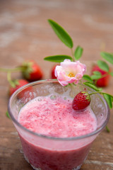 Strawberry milk and rose on wood table